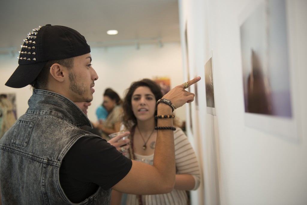 Carlos Garcia admires a collection of photographs at the BEND exhibition opening at the Frost Museum.  BEND focuses on LGBTQA lived experiences, especially as they relate to issues of empowerment and equality. BEND will be at the Frost until June 11. 