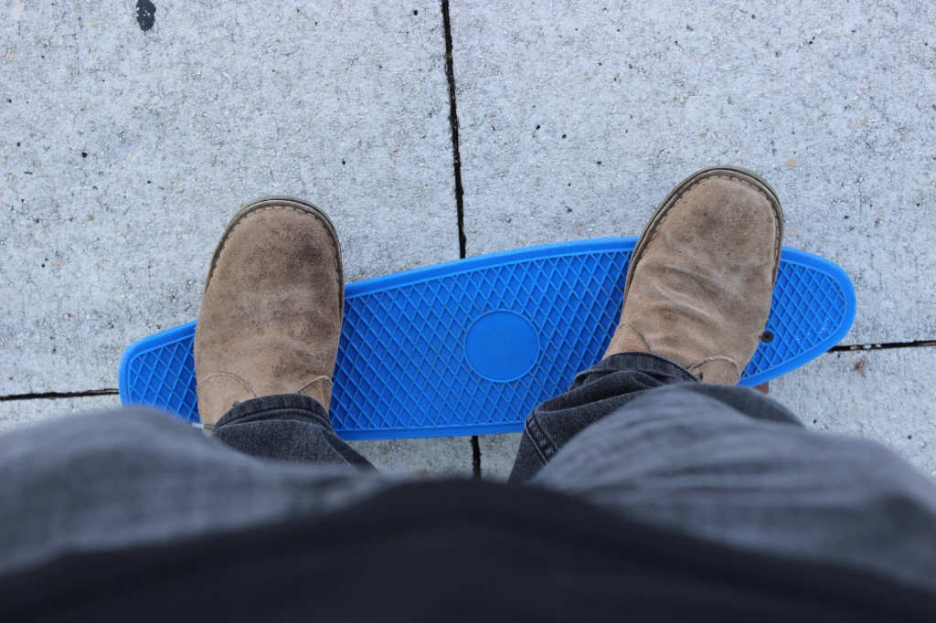 An imitation Penny Skateboard. Notice the toes hanging off the edges of the deck. 